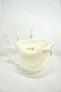 A Glass Cup with Milk on White Surface