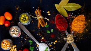 Collection of bright spices and fresh vegetables on table